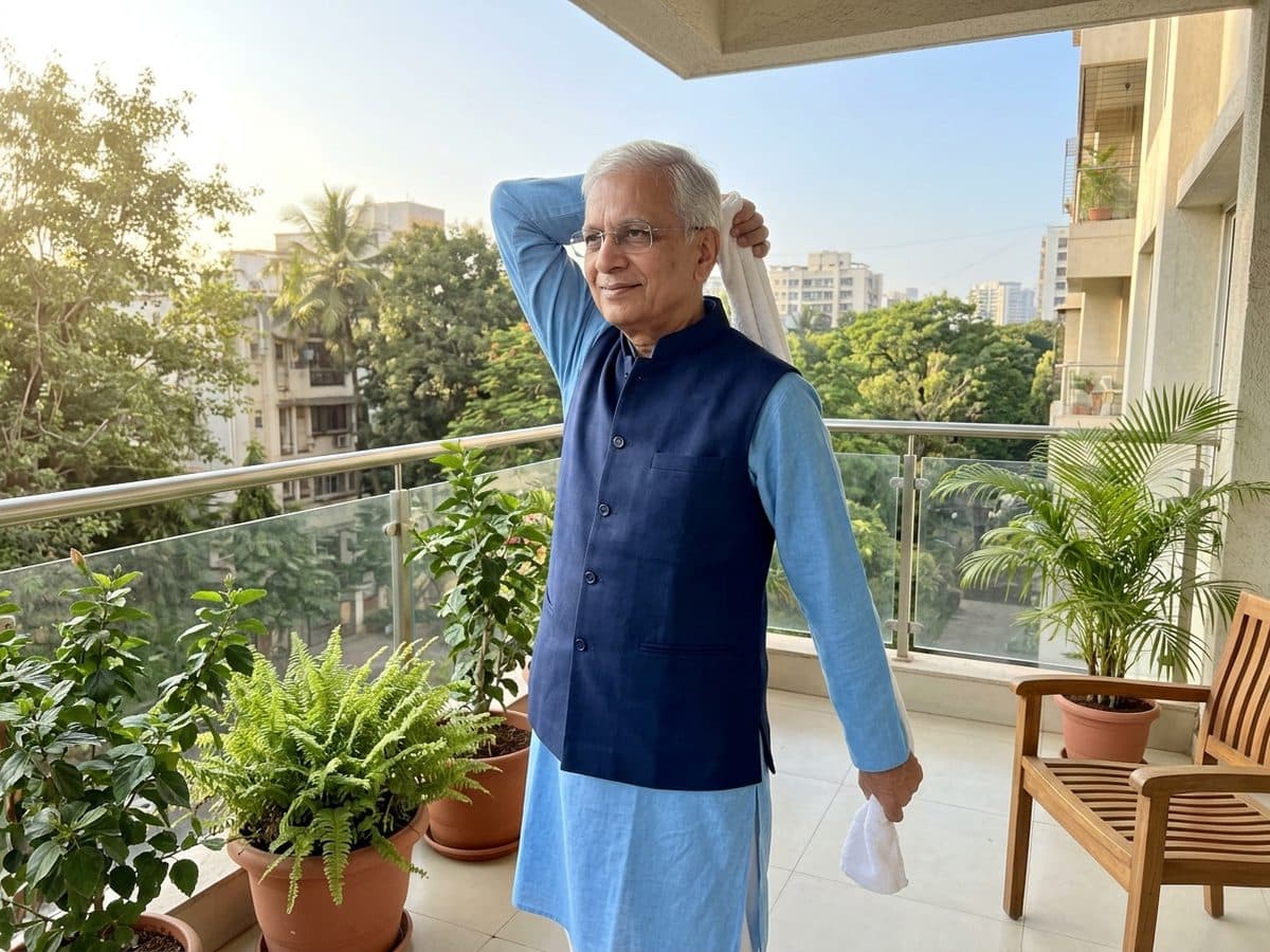 Towel stretch behind the back: an older Indian adult demonstrating the exercise at home